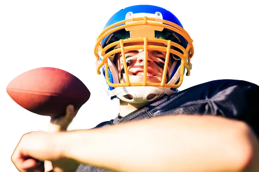 An American football player wearing a blue and yellow helmet smiles as he prepares to throw a ball. His face is painted black and he is wearing a black jersey. It's a sunny and bright day.